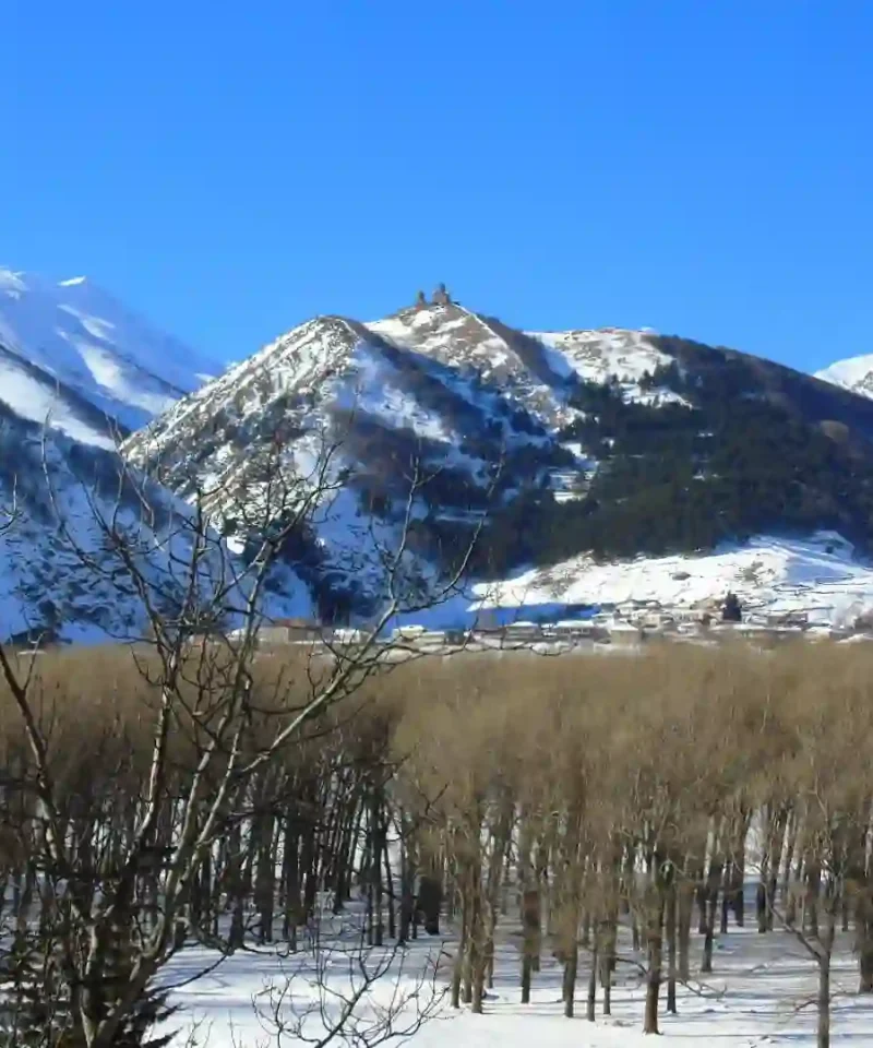 Snowy peak of Mount Kazbek behind Gergeti Trinity Church