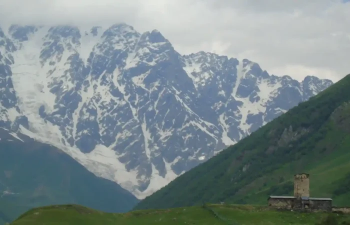 Ancient tower and the Lamaria Church in Ushguli, a religious landmark on a cultural tour in Georgia