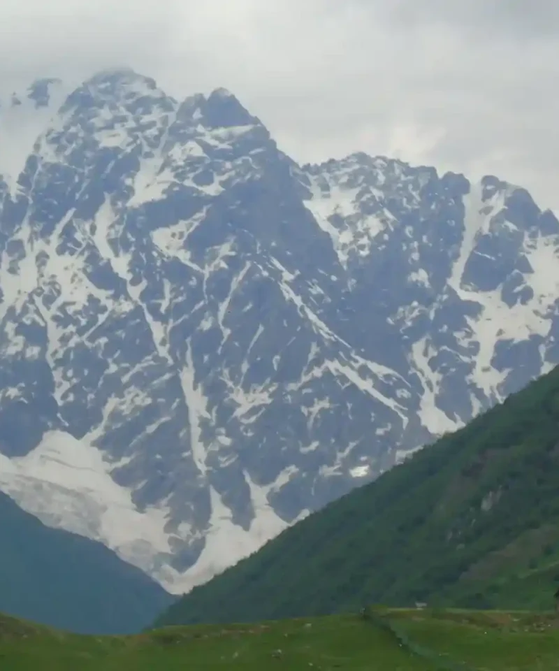 Ancient tower and the Lamaria Church in Ushguli, a religious landmark on a cultural tour in Georgia