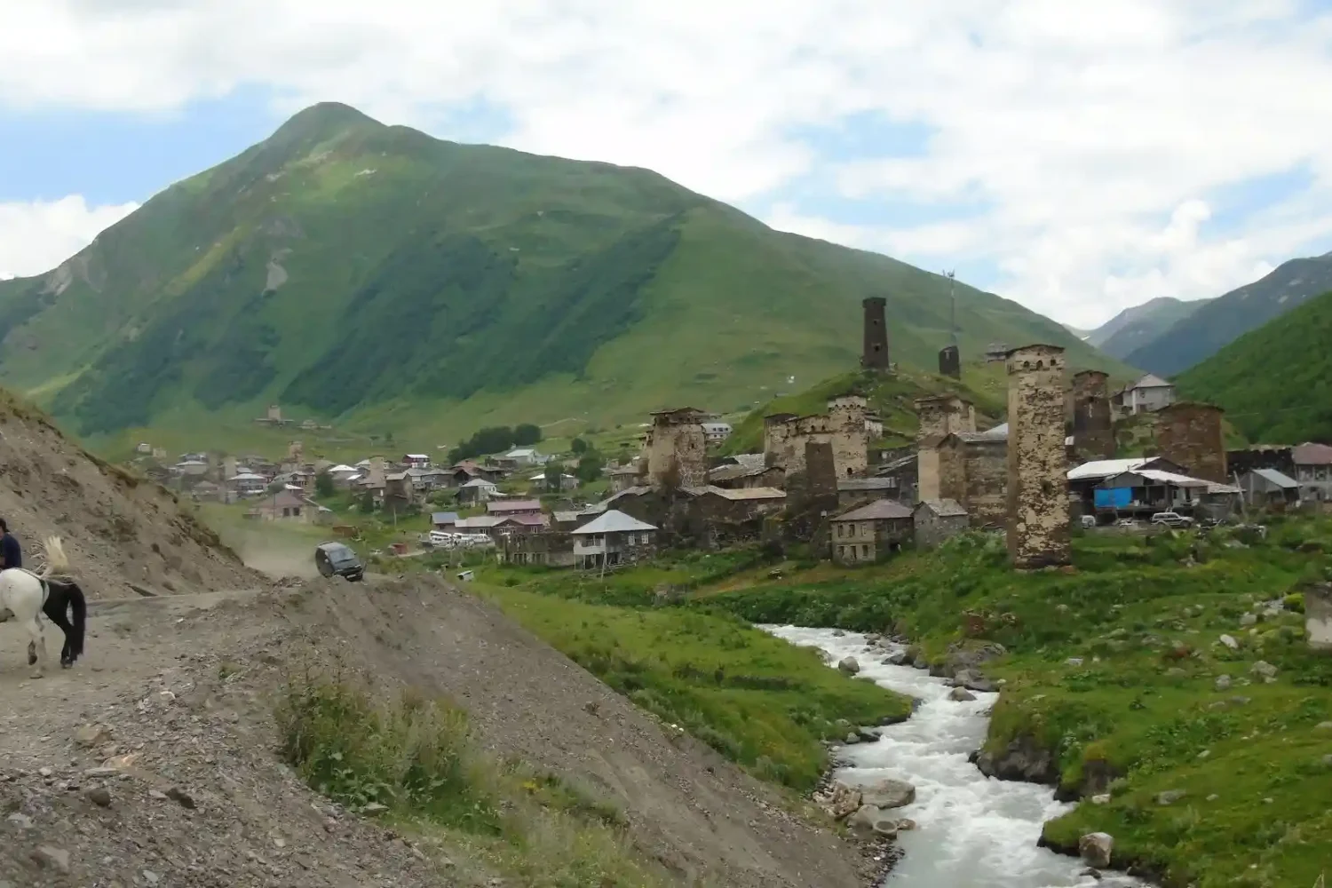 A small river is visible at the entrance to the village.