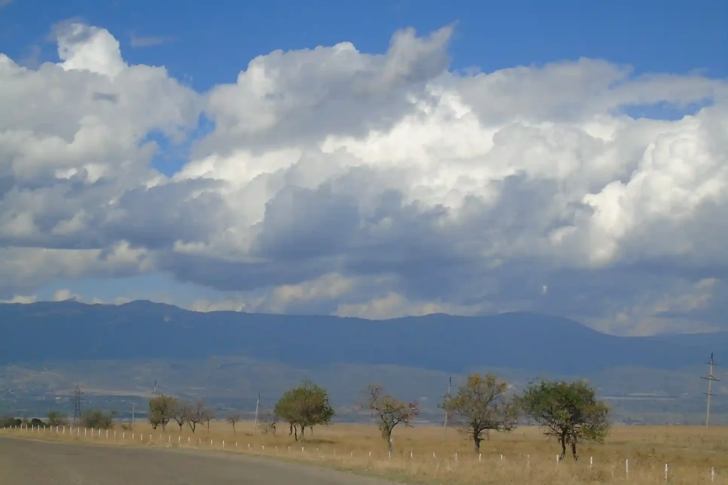 Open road to David Gareja with fluffy white clouds