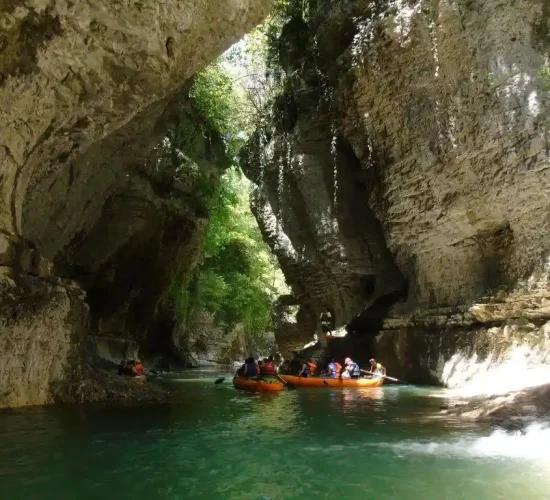 Tourists in life vests boating through the deep green Martvili Canyon