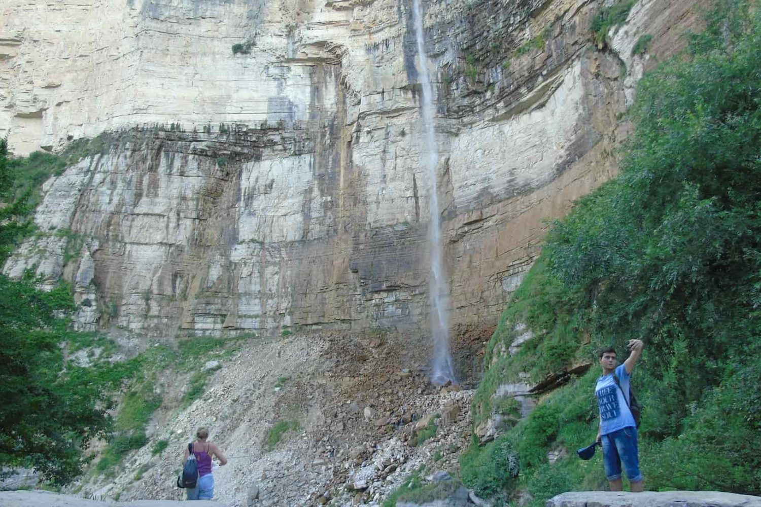 Okatse Waterfall, summer, tourists, woman and man taking a selfie